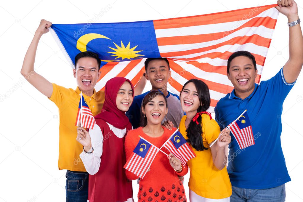 people holding malaysia flag celebrating independence day