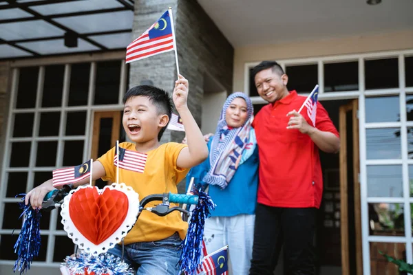 boy riding his bicycle full with malaysia flag