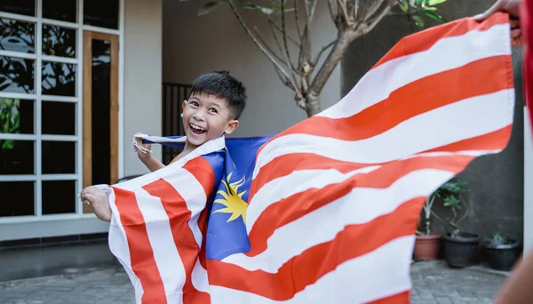 Garoto malaio com bandeira correndo — Fotografia de Stock