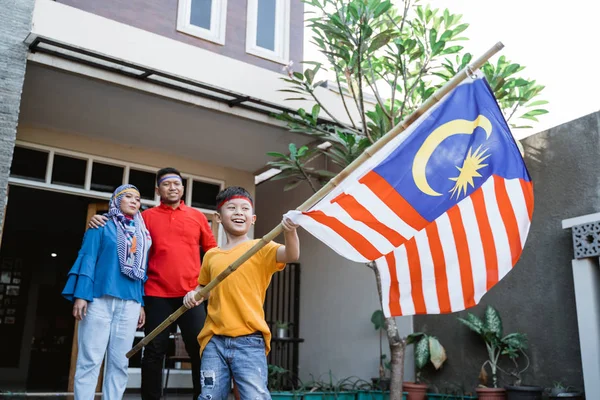 Menino levantando bandeira malaia com orgulho — Fotografia de Stock