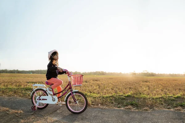 Independent asian child ride her bicycle — Stock Photo, Image