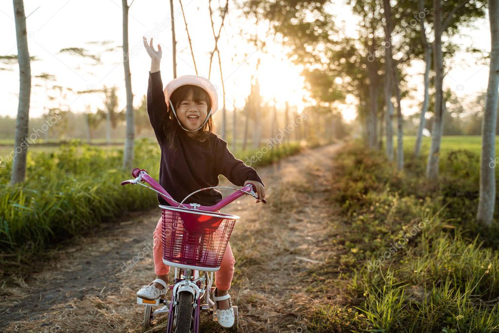 independent asian child ride her bicycle