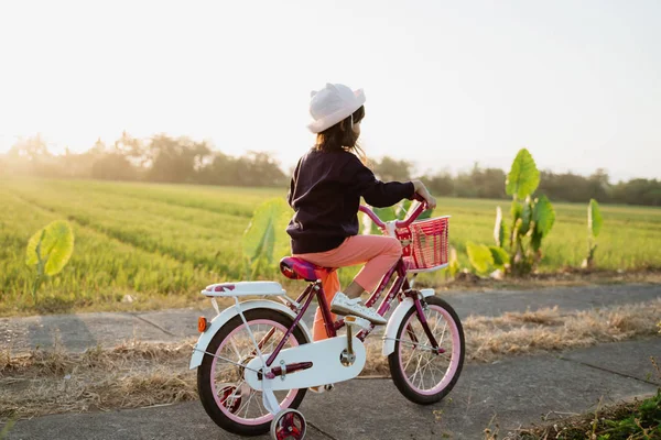 Oberoende asiatiska barn rida hennes cykel — Stockfoto