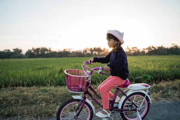 Ragazza felice cavalcando la sua bicicletta all'aperto — Foto Stock