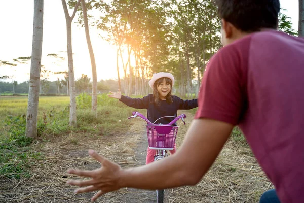 Padre ayudar a niño a montar bicicleta al aire libre — Foto de Stock