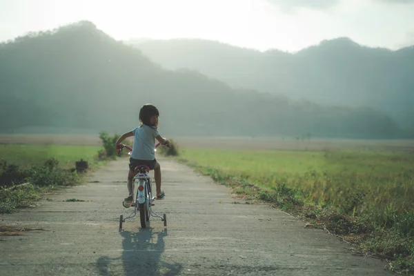 Niezależne Azjatyckie dziecko jeździć jej rower — Zdjęcie stockowe