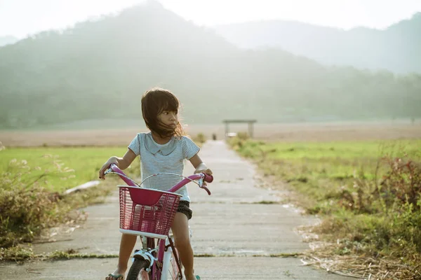 Onafhankelijk Aziatisch kind berijd haar fiets — Stockfoto