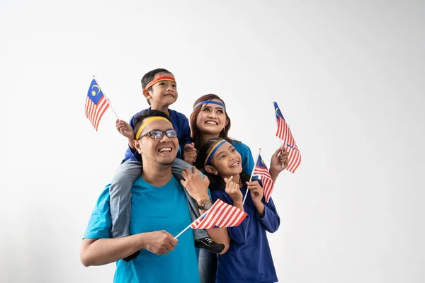 Familia malaysia con atributos y bandera celebrando — Foto de Stock