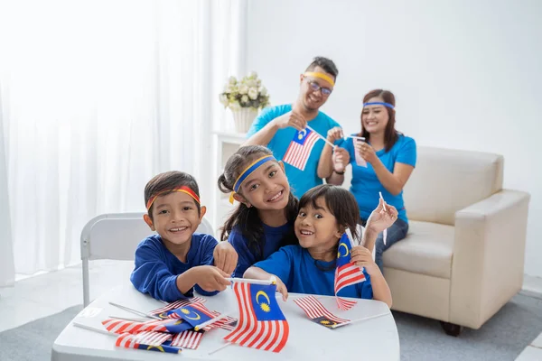 family creating malaysia flag for independence day