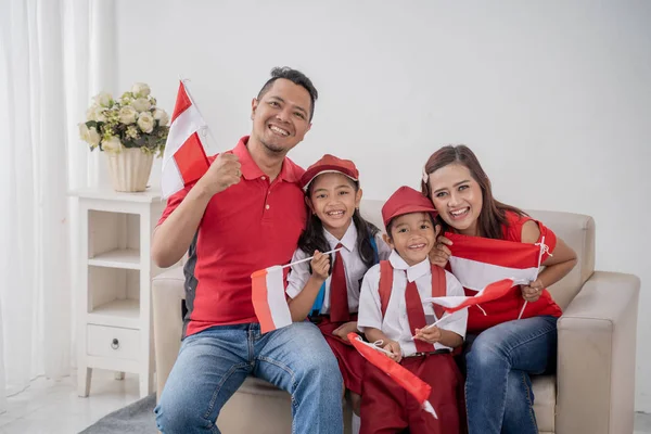 Endonezyalı aile beyaz arka plan üzerinde Endonezya bayrağı tutarak — Stok fotoğraf