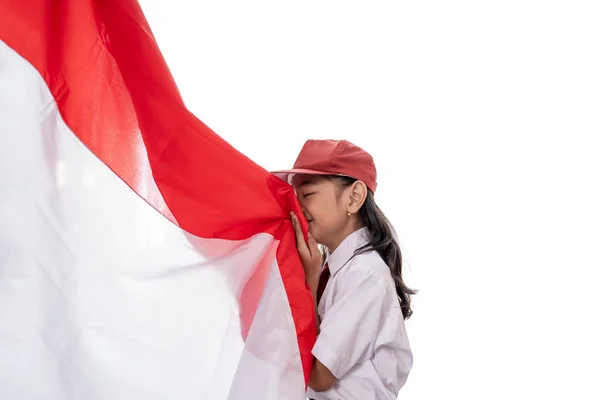Skolflicka kysser Indonesien flagga — Stockfoto