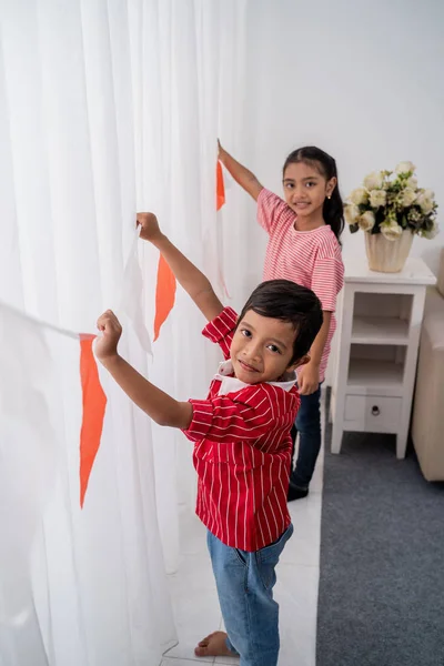 Familia decorando su casa con bandera indonesia —  Fotos de Stock
