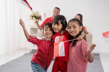 Endonezyalı aile beyaz arka plan üzerinde Endonezya bayrağı tutarak