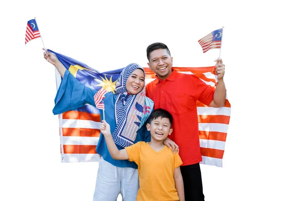 Família malaia segurando bandeira malaia na frente de sua casa — Fotografia de Stock