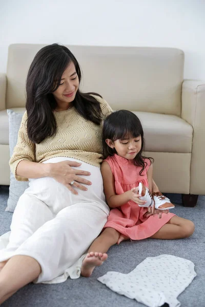 Asiatisk liten flicka som innehar baby skor — Stockfoto