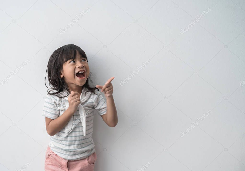 asian cute little girl surprised with finger pointing