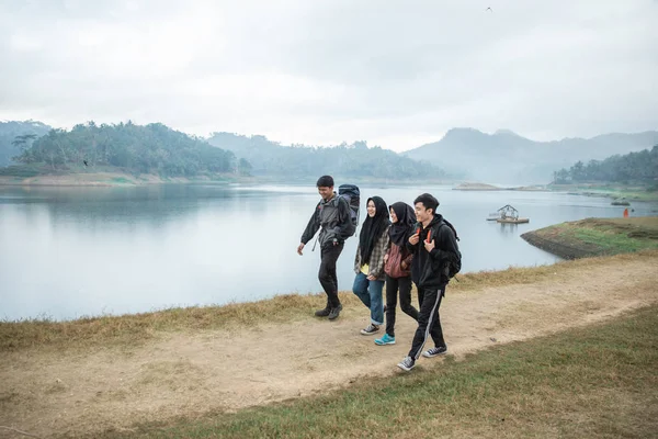 Група друзів у пішохідному туризмі насолоджуються видом на озеро — стокове фото