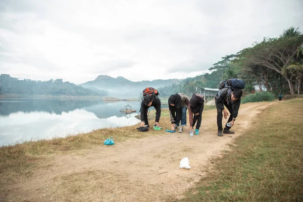 Hikers pick up trash while traveling