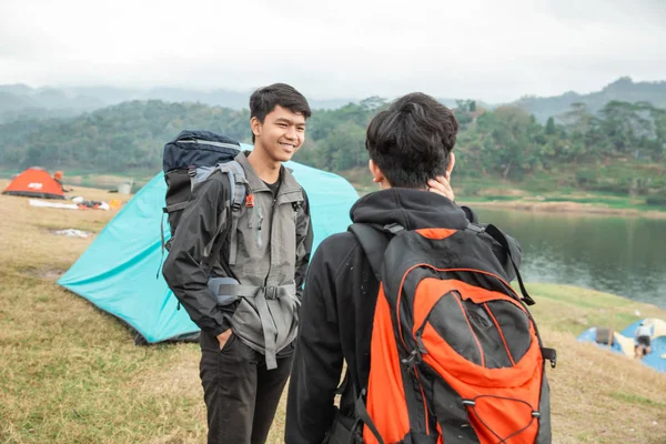 Dos viajeros asiáticos de pie cerca del lago —  Fotos de Stock