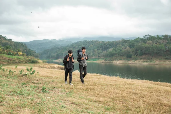 湖の近くに立つ2人のアジア人旅行者 — ストック写真
