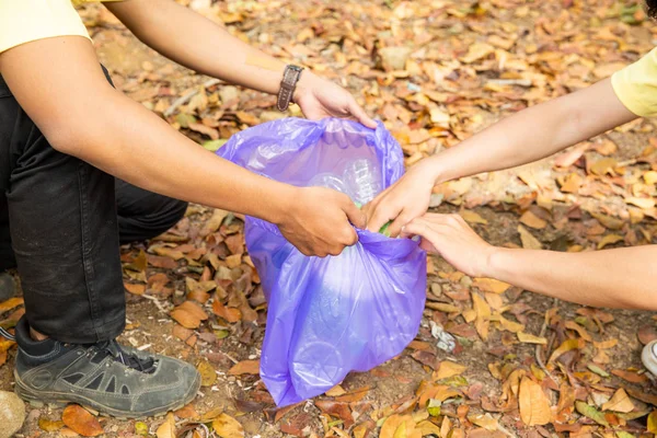 Handen van jonge vrijwilligers het schoonmaken van afval — Stockfoto