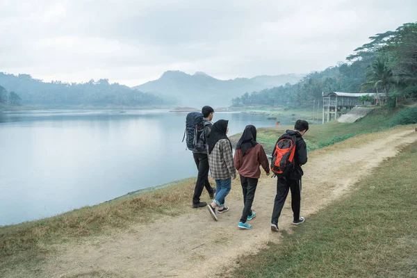 Група друзів у пішохідному туризмі насолоджуються видом на озеро — стокове фото