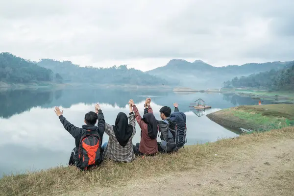 Grupo de caminhantes descansando ao lado do lago — Fotografia de Stock