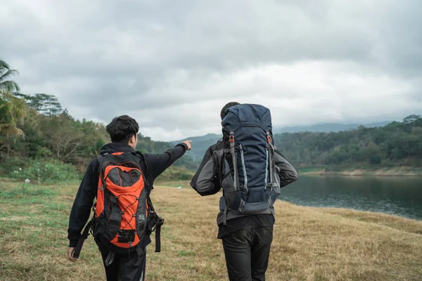 Twee man wandelliefhebbers trekking in de buurt van het meer — Stockfoto