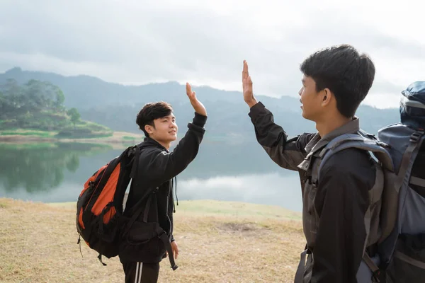 Two asian travelers with toast standing near lake — Stock Photo, Image