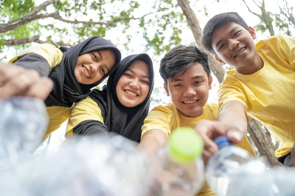 亚洲青少年志愿者把瓶子垃圾放在垃圾袋 — 图库照片