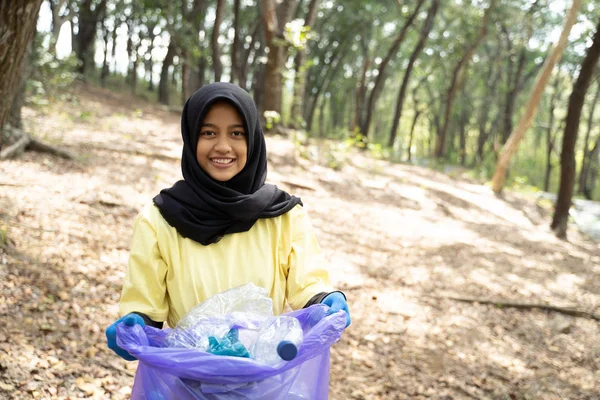 Hijab femme souriant bénévole tenant sac poubelle — Photo