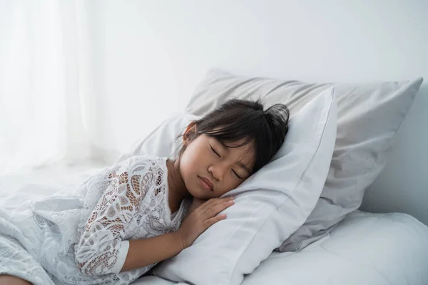 Азиатская девочка лежит на кровати — стоковое фото