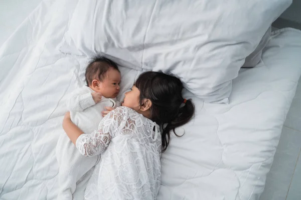 Hija niño con bebé hermano jugando en la cama vistiendo blanco — Foto de Stock