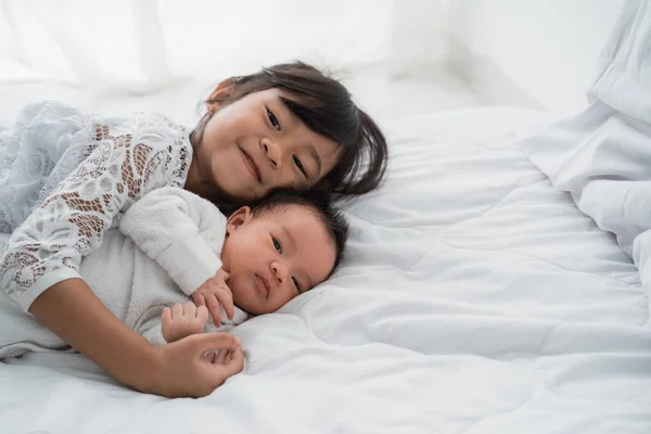Hermana con su bebé recién nacido hermanito jugar juntos —  Fotos de Stock
