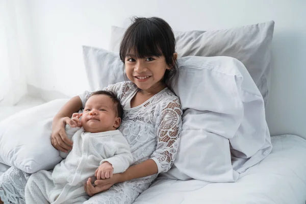 Sonriente feliz chica hermano bebé acostado en la cama —  Fotos de Stock