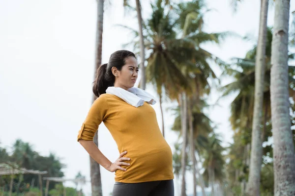 Kobieta w ciąży ból pleców podczas ćwiczeń na zewnątrz — Zdjęcie stockowe