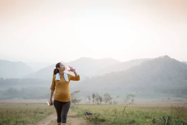 Mujer embarazada después del entrenamiento bebiendo una botella de agua —  Fotos de Stock