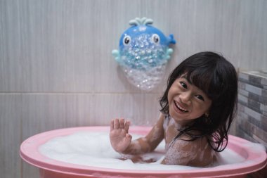 Köpük ile banyo yaparken Asya küçük kız smilling