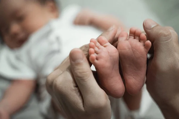 Matka ruce držící baby nohy — Stock fotografie