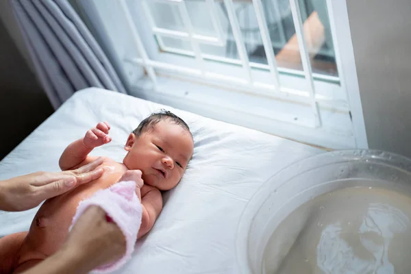 어머니와 함께 젖은 수건을 사용하여 신생아 베이 목욕 — 스톡 사진