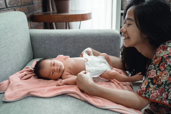 Asiático madre cambiar pañal a su pequeño hija —  Fotos de Stock