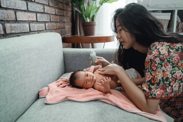 Asijská matka, která používá telový olej její dcerce — Stock fotografie