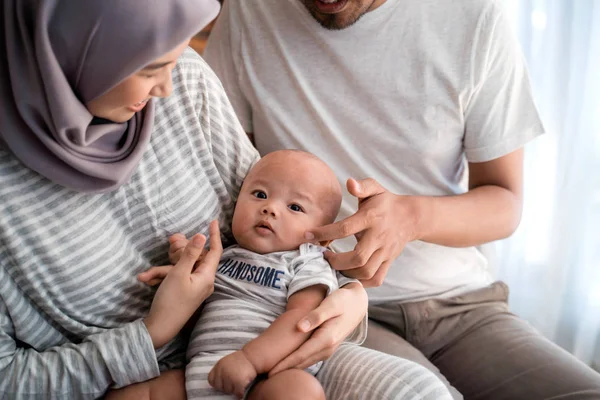 Мусульманские родители со своим новорожденным ребенком в гостиной — стоковое фото