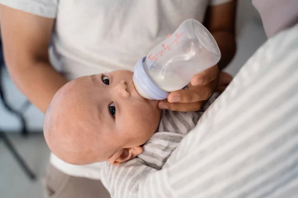 Родитель кормит ребенка бутылкой молока — стоковое фото