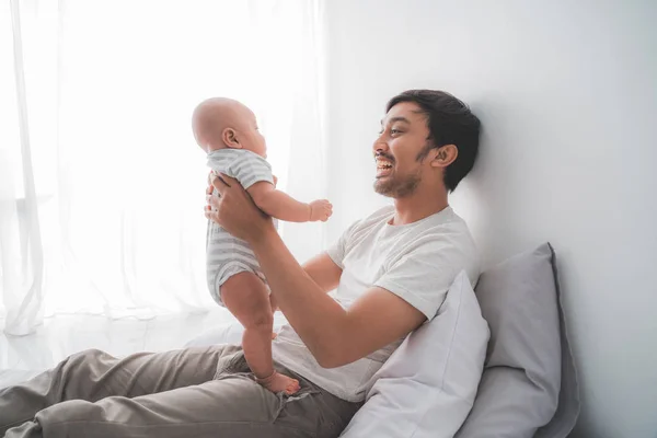 Vader draagt zijn baby jongen samen spelen thuis — Stockfoto