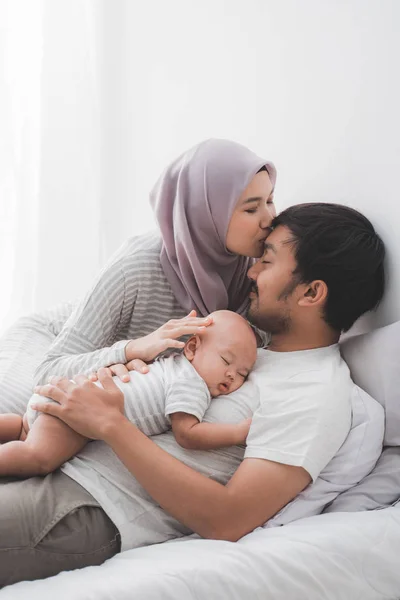 Muslimské rodičovský polibek spolu s chlapským chlapcem — Stock fotografie