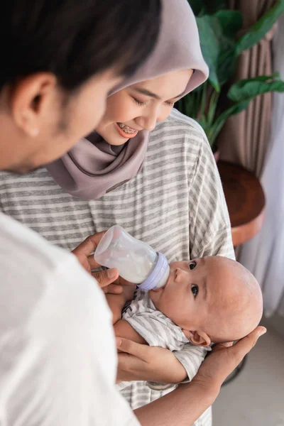 젖병에 우유를 가진 부모 먹이 아기 소년 — 스톡 사진