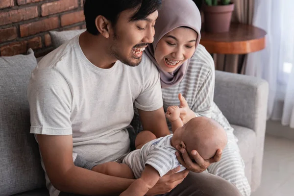 asian family with infant son together smiling