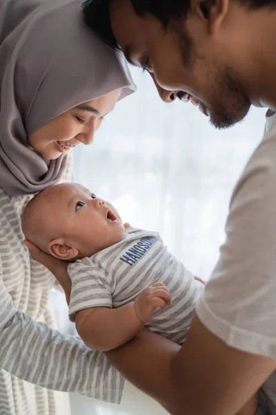 asian family with infant son together smiling