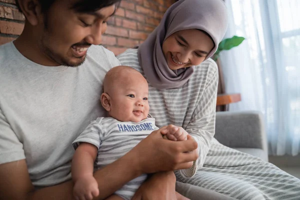 asian family with infant son together smiling